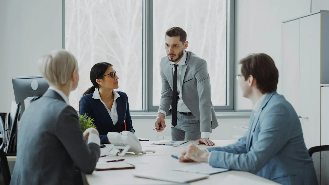 Profesionales revisando documentos y conversando en una reunión de asesoría empresarial
